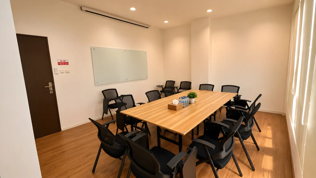 Ruang training dan meeting InMind Mental Health Clinic dengan meja panjang, kursi peserta, whiteboard, dan suasana profesional yang nyaman.